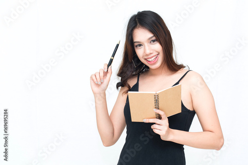 Young Asian woman taking notes in notebook with white background