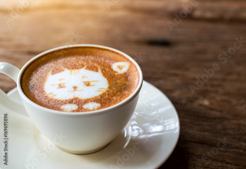 Fototapeta Stawia czoło kota projekt latte sztuki kawa w białej filiżance na drewno stole