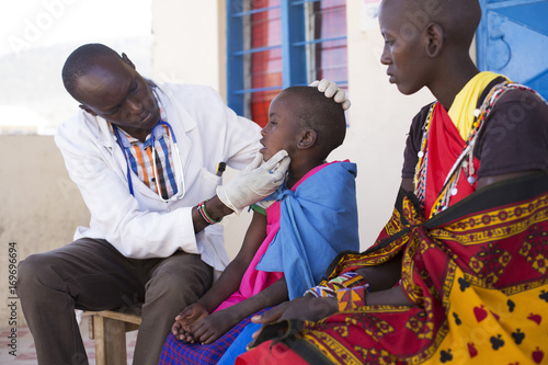 Doctor examining young girl from the Maasai tribe. Kenya, Africa.