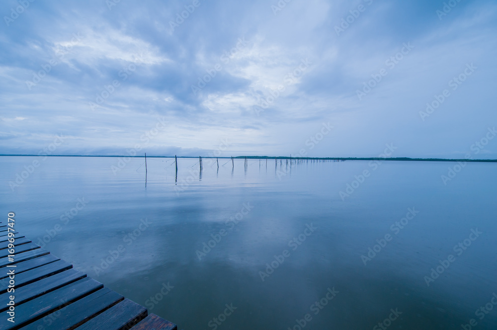 Naklejka premium wooden pier and sea in morning of rainy day.