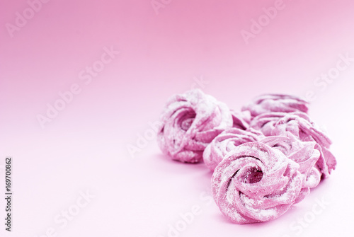 delicate pink marshmallow in powdered sugar, on a pink background