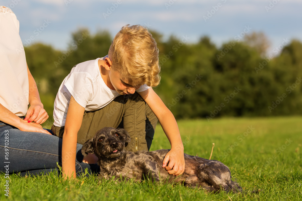 mother with son playing with a small dog mother with son playing with a small dog