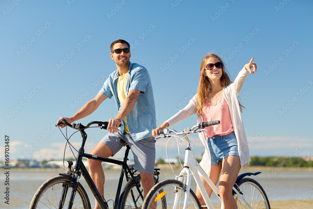 happy young couple riding bicycles at seaside happy young couple riding bicycles at seaside