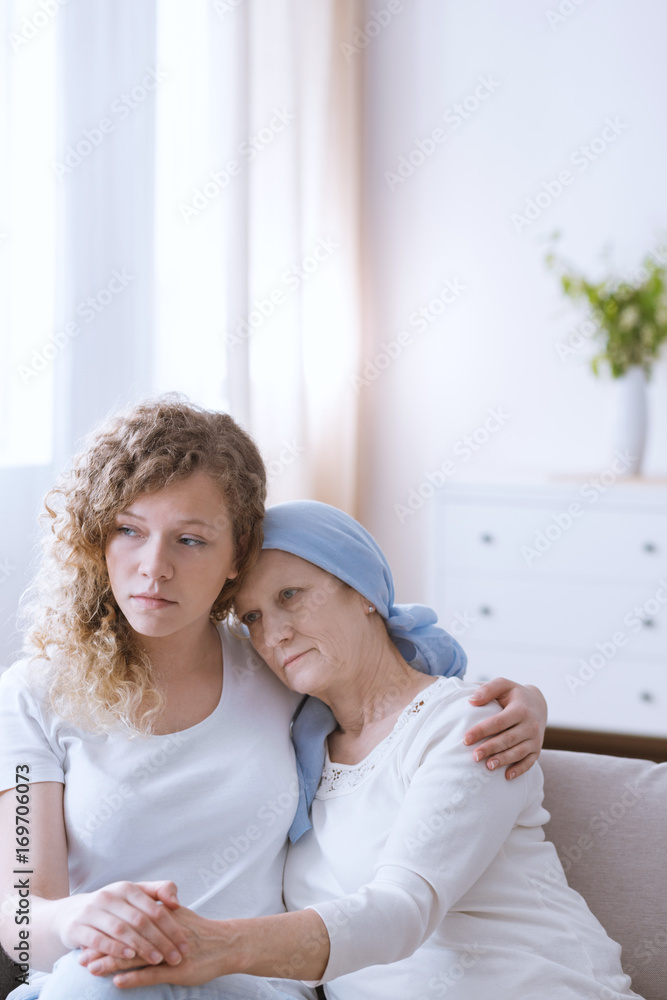 Woman with headscarf embraced by daughter Woman with headscarf embraced by daughter