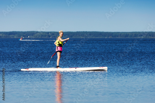 sup - woman on stand up paddle board in the lake