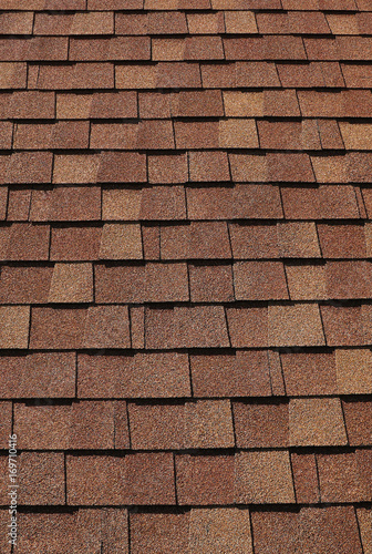 Texture of grey and brown roof tiles on a bright day