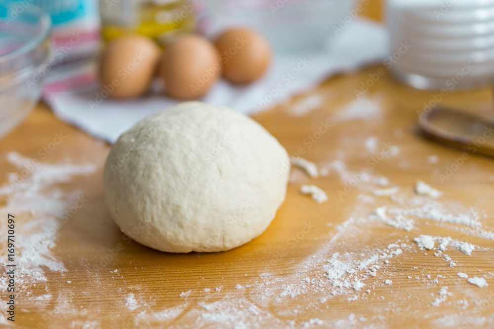 Dough, eggs and rolling pin on the kitchen table for cooking. Concept holiday and home comfort.