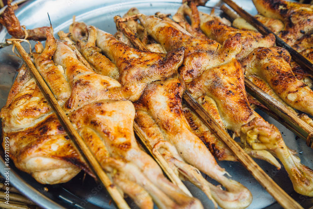 Roast chicken with bamboo on the grill, Local Foods of Thailand.