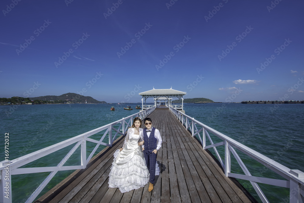 Asian couple with pre wedding sceen outdoor the sea at sunset is falling  and Wood waterfront pavilion, at Koh Si Chang island in Thailand background.,thai  lover Stock Photo | Adobe Stock