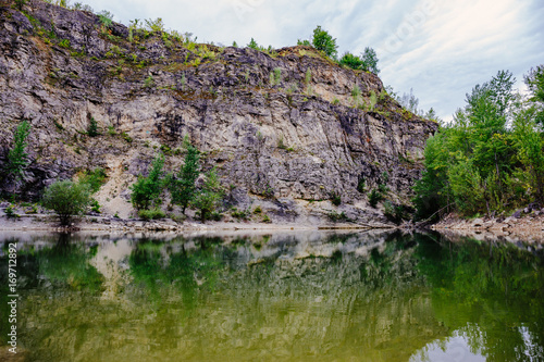 Lake with reflection of rocks, natural mountain landscape, abandoned quarry with lake