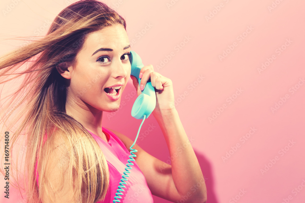 Young woman talking on old fashioned phone