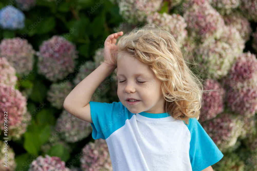 Cute small child with many flowers in the garden Cute small child with many flowers in the garden