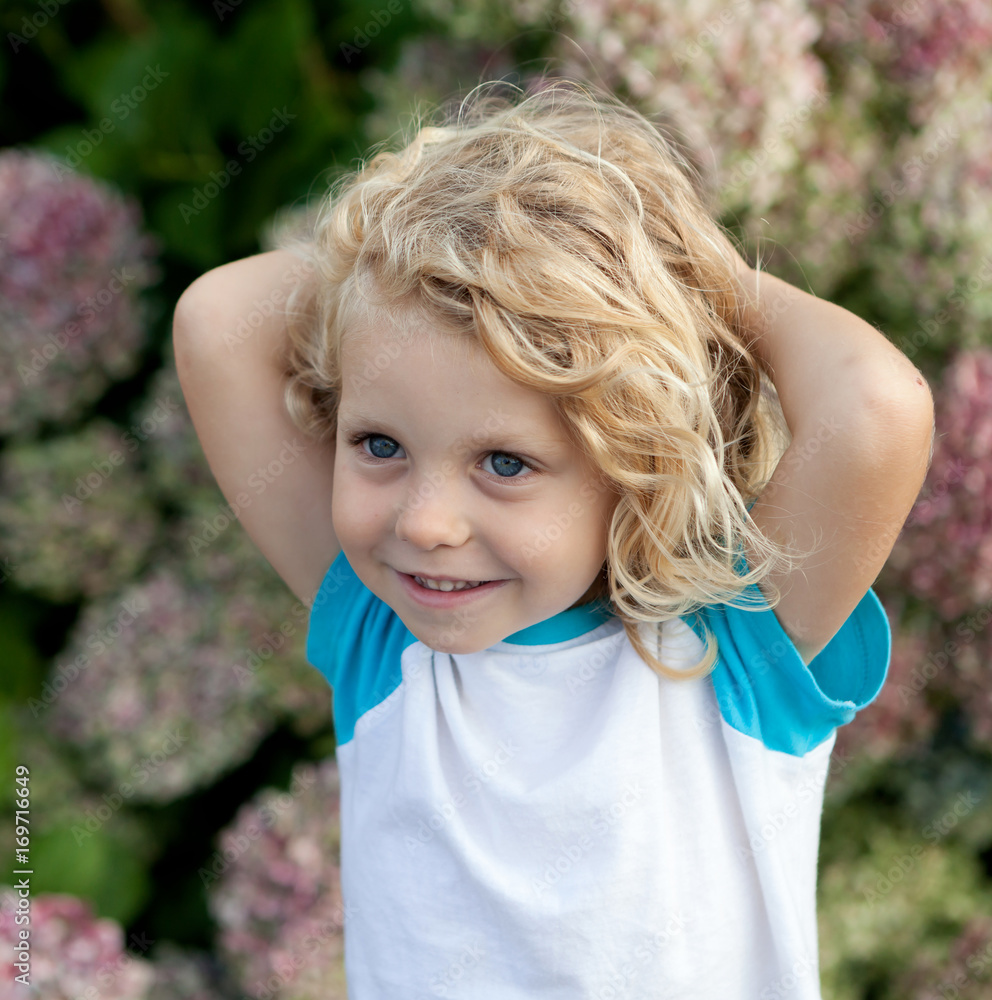 Cute small child with many flowers in the garden Cute small child with many flowers in the garden