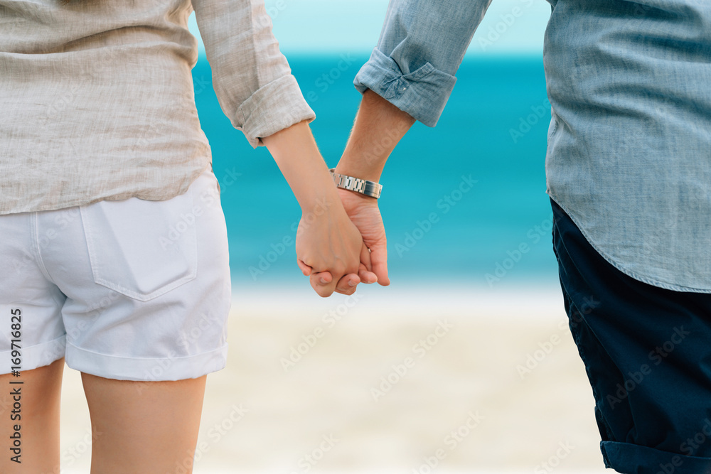 Junges Paar Hand haltend im Urlaub am Strand Junges Paar Hand haltend im Urlaub am Strand