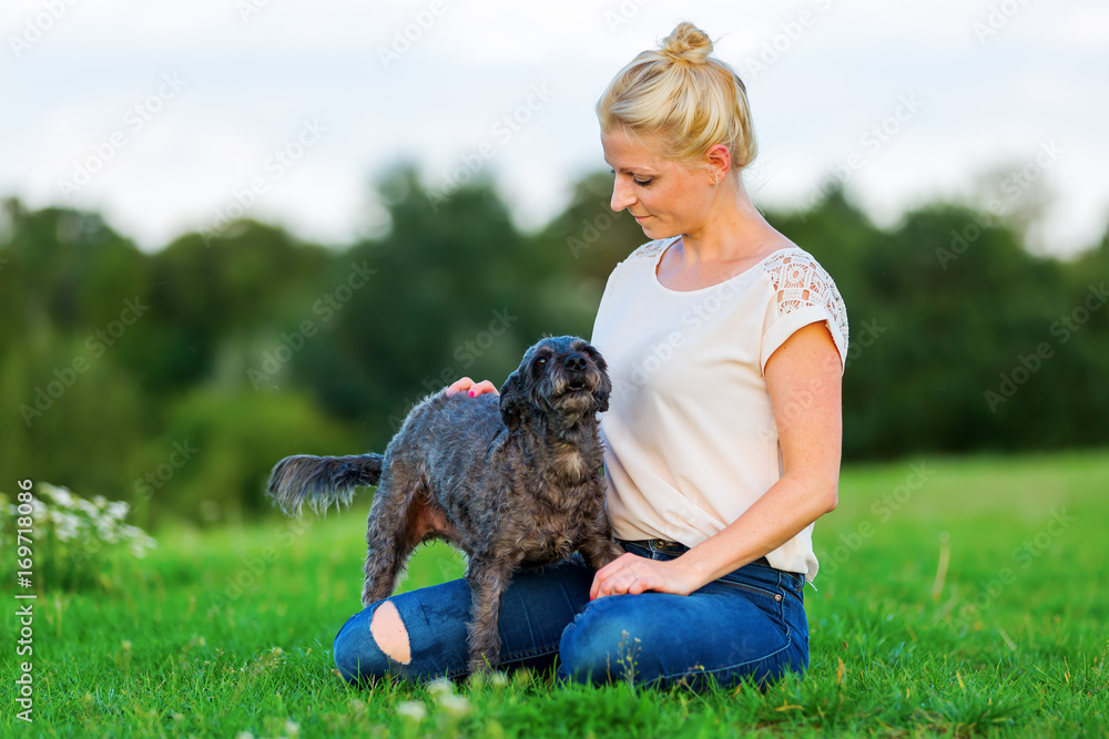 woman plays with a terrier hybrid outdoors woman plays with a terrier hybrid outdoors