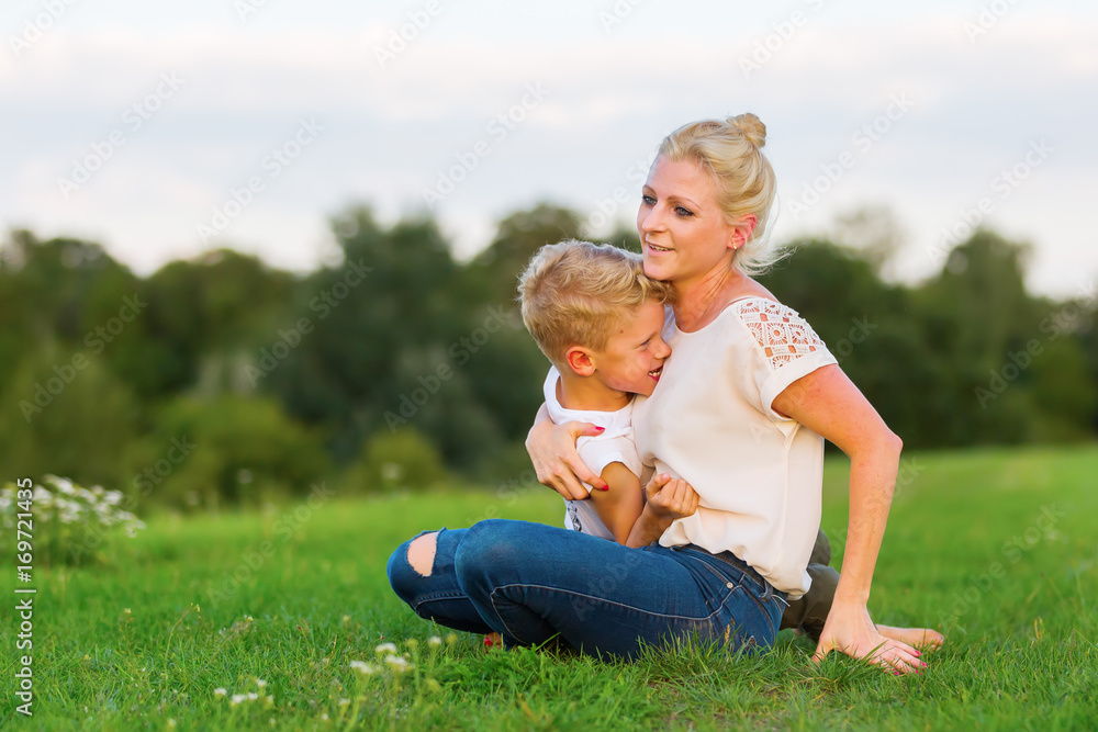 woman romps with her son on the grass woman romps with her son on the grass