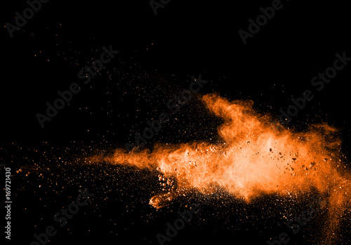abstract orange dust explosion on black background. abstract orange powder splatted on black background, Freeze motion of orange powder exploding.