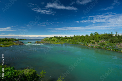 Iceland - Blue sky over turquoise river at estuary into the sea in blonduos