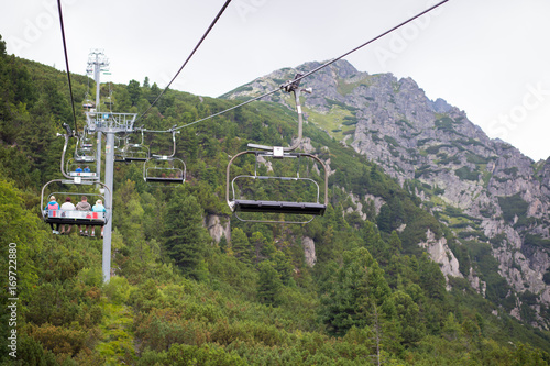 Empty cableway going top of the hill, massive moutains