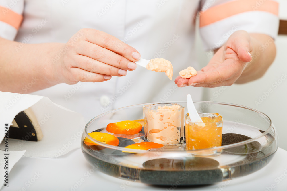 Woman applying cream on hand using spatula Woman applying cream on hand using spatula