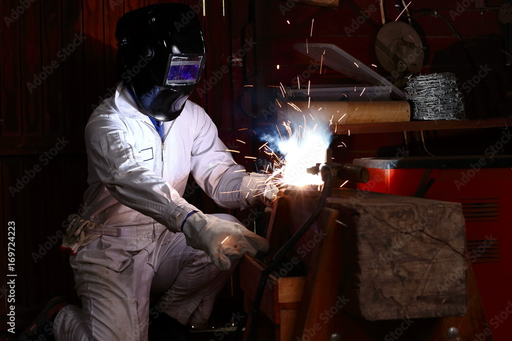 Professional welder in safety uniform welding metal in the factory. Industrial concept.