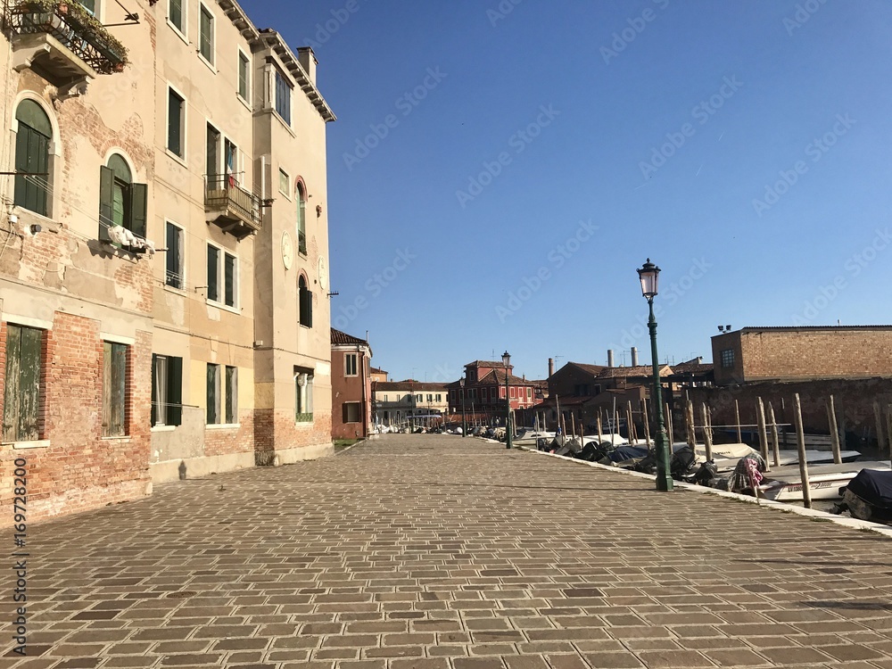 Rue piétonne pavée à Murano, quartier calme près de venise, ensoleillé 