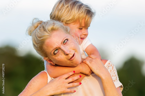 Konstfotografi woman romps with her son on the grass
