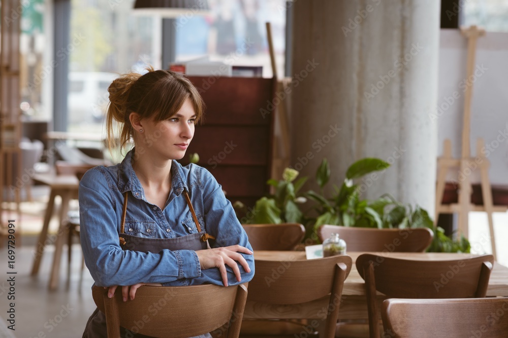 Waitress sitting on a chair in cafe Waitress sitting on a chair in cafe