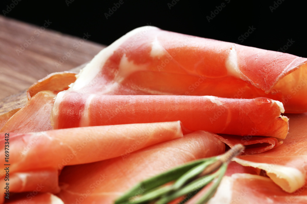 Italian prosciutto crudo or jamon with rosemary. Raw ham. Italian prosciutto crudo or jamon with rosemary. Raw ham.
