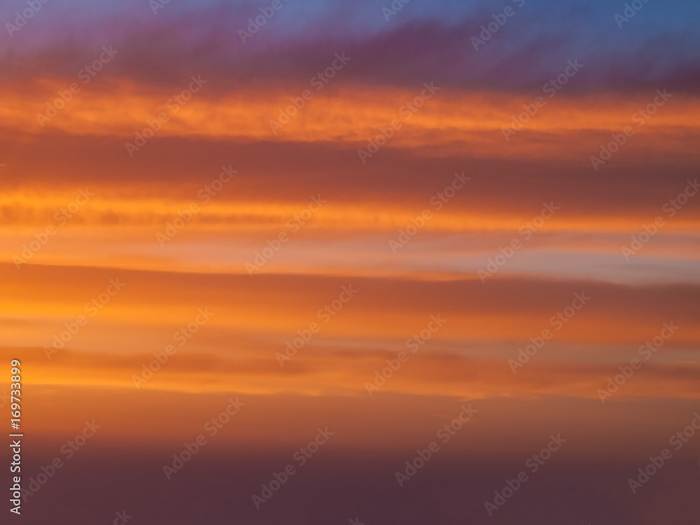 Horizontal clouds of orange and violet in the rays of sunset