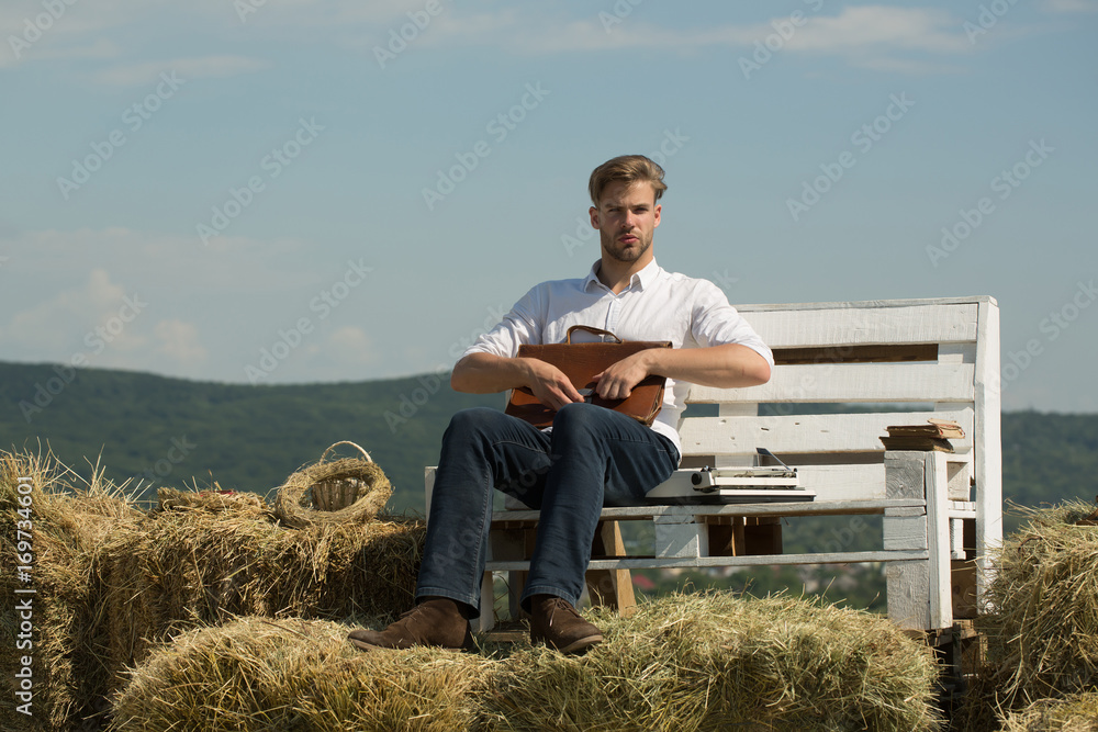 Macho holding briefcase on natural landscape Macho holding briefcase on natural landscape