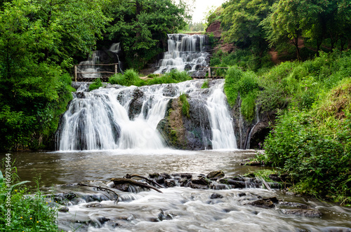Cascaded waterfall in a green forest. Dzhurinsky waterfall Ukraine.