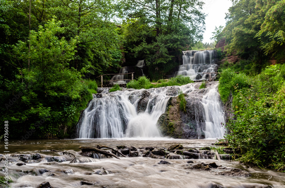 Obraz premium Cascaded waterfall in a green forest. Dzhurinsky waterfall Ukraine.