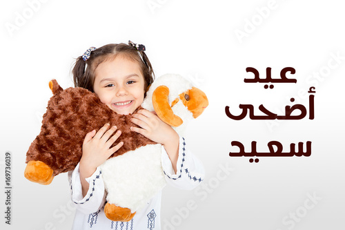 Happy little girl playing with her sheep toy - celebrating Eid ul Adha - Happy Sacrifice Feast photo