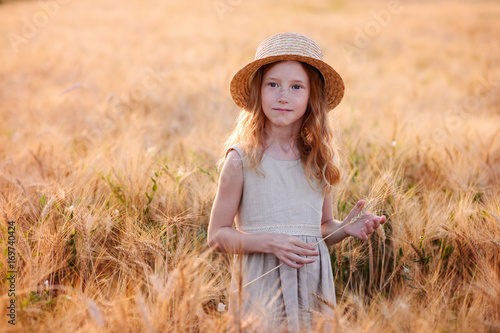 Beautiful child play a field of wheat