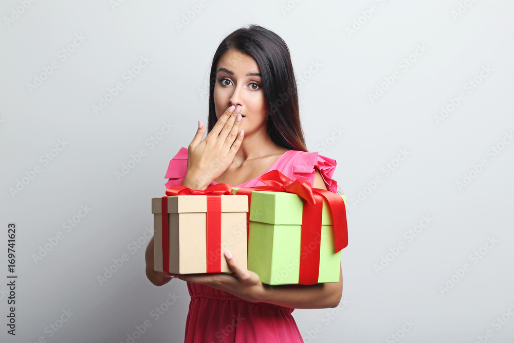 Portrait of beautiful woman holding gift boxes on grey background Portrait of beautiful woman holding gift boxes on grey background