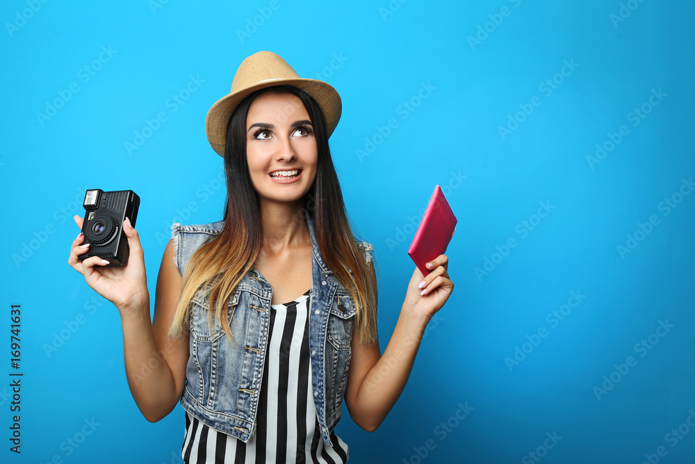 Happy young woman tourist holding passport and retro camera Happy young woman tourist holding passport and retro camera