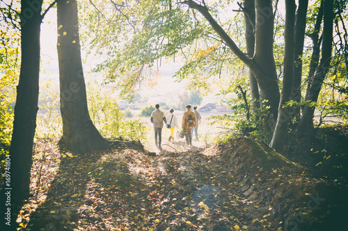 Film photos of group of people on the walk. Family in the hike. People go up the road.