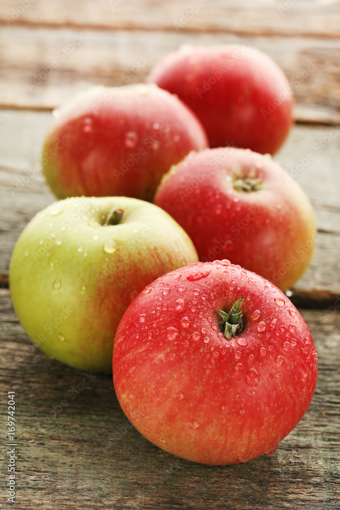 Ripe and sweet apples with water drops on wooden table Ripe and sweet apples with water drops on wooden table