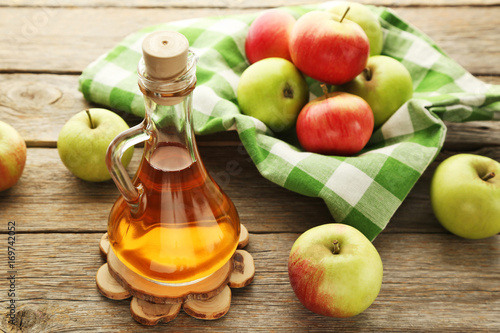 Fototapeta Naklejka Na Ścianę i Meble -  Apple vinegar in glass bottle on grey wooden table