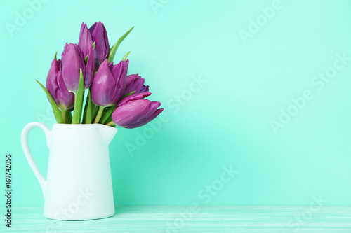 Fototapeta Naklejka Na Ścianę i Meble -  Bouquet of tulips in jug on green background