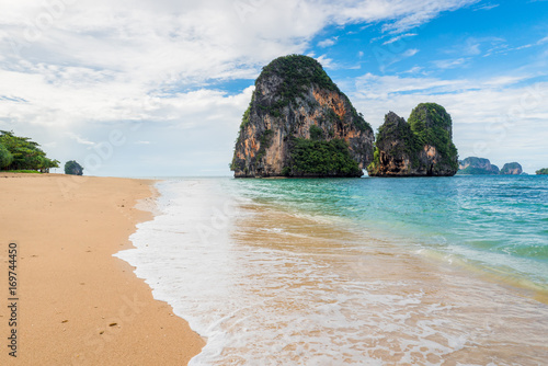 Turquoise water of the Andaman Sea rolling waves on the sandy beach of Thailand