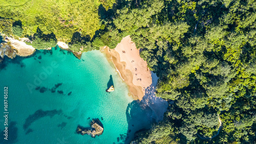 Fototapeta Naklejka Na Ścianę i Meble -  Aerial view on a small beach surrounded by rocks and forest. Coromandel, New Zealand