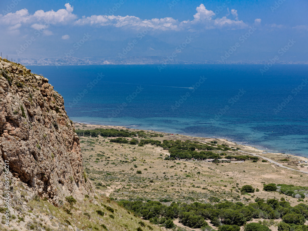 Beautiful mediterranean sea view with high cliffs of Santa Pola Faro del Cabo Spain. Tabarca island is in the distance.