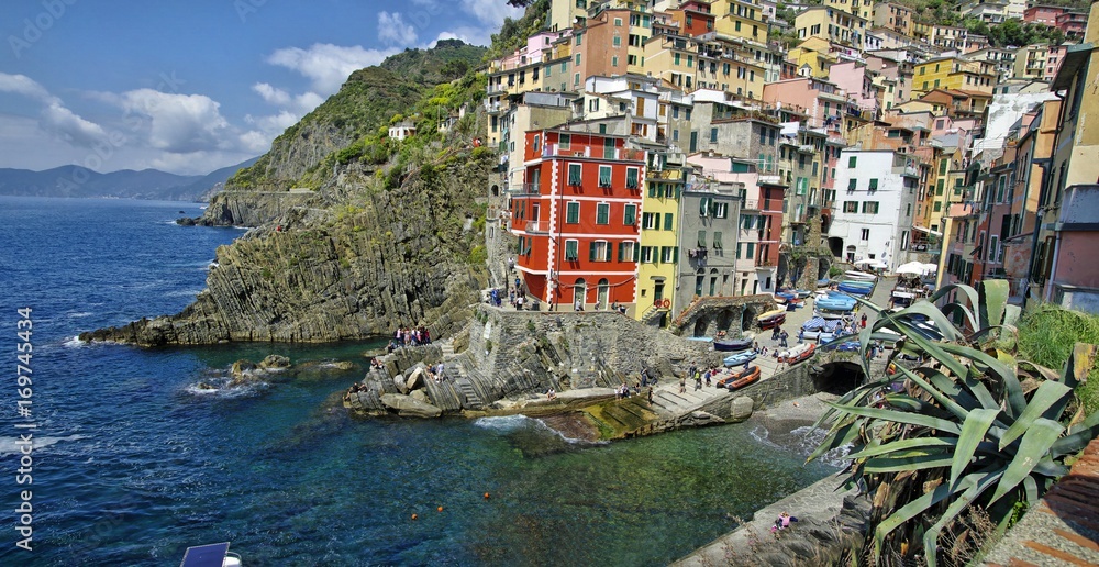 View of the colorful houses in a sunny day in Riomaggiore, Italy on April 14, 2016. Riomaggiore is one of the five famous Cinque Terre villages
