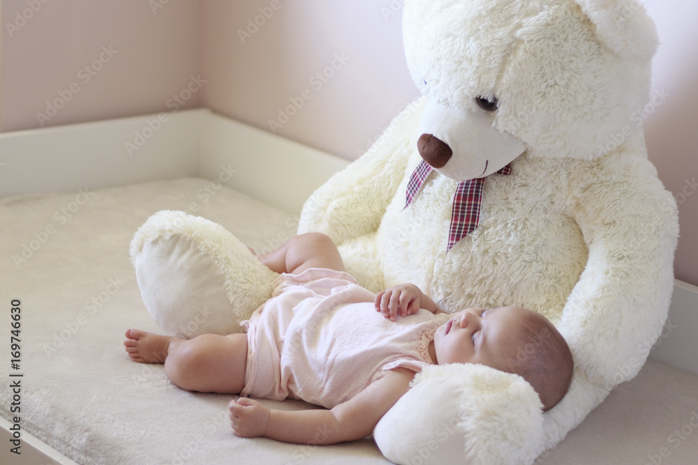 Bebé durmiendo sobre el regazo de un oso de peluche Stock Photo | Adobe  Stock