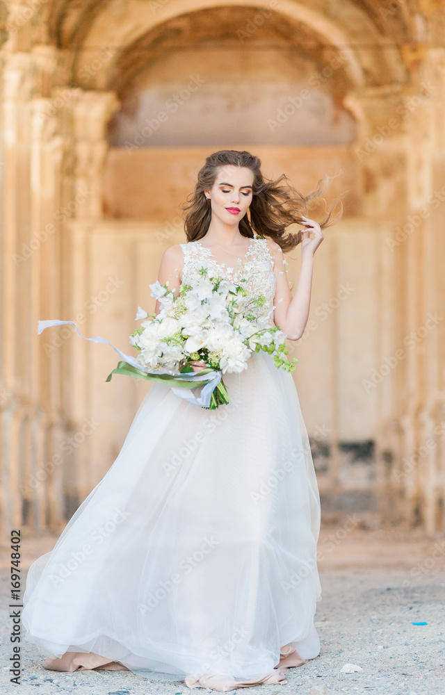 Romantic beautiful bride in luxury dress posing of beautiful architecture
