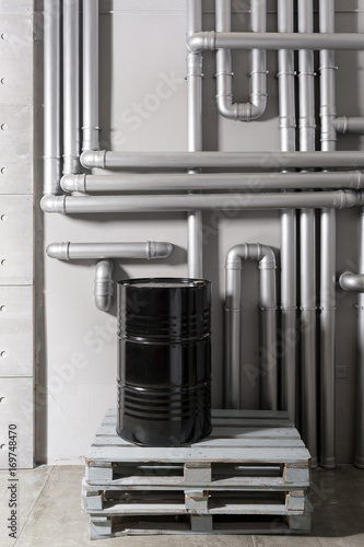 black barrel and tubing - concept. silver pipeline system in crude oil factory