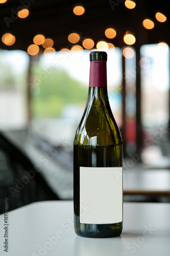 red wine bottle on white table photo