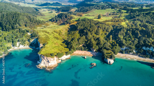 Aerial view on a small beach surrounded by rocks and forest. Coromandel, New Zealand